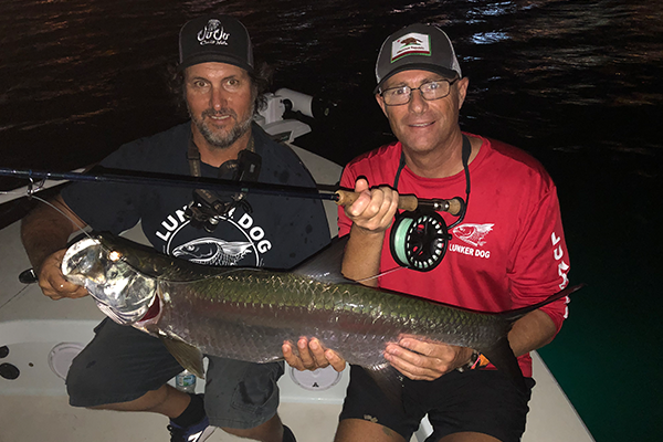 Two anglers showing off a catch in Miami