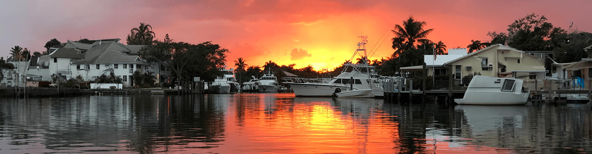 Boats docked at a Fort Lauderdale harbor at sunset