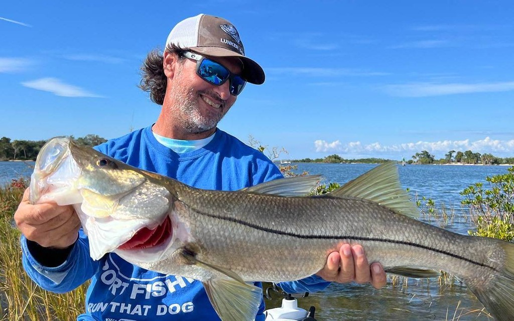 Fisherman with a catch standing in water near Miami