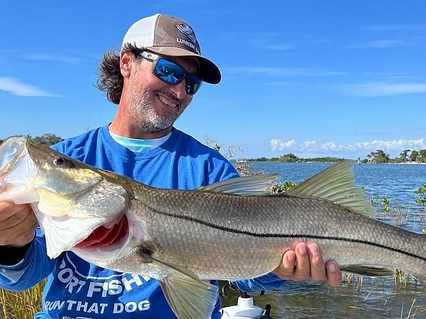 Fisherman with a catch standing in water near Miami